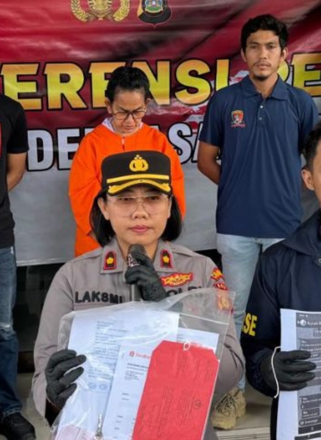 Maharani Aisyah Rasyid presented by police following her arrest in the shop rental fraud case.